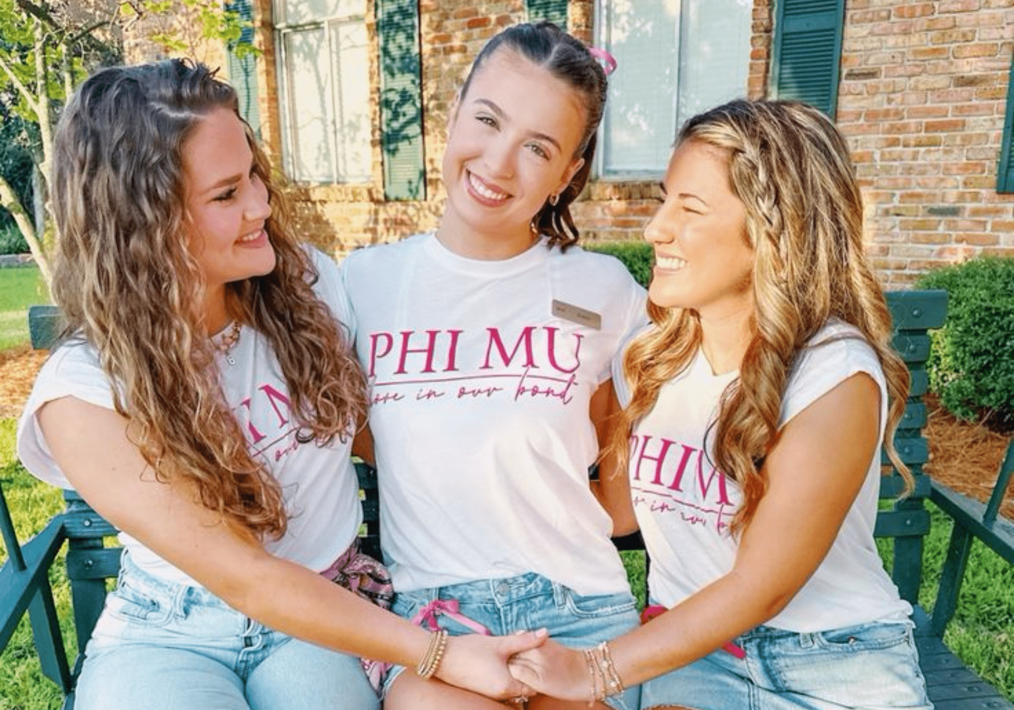 Photo of 3 Phi Mu members wearing Phi Mu tees and nametags